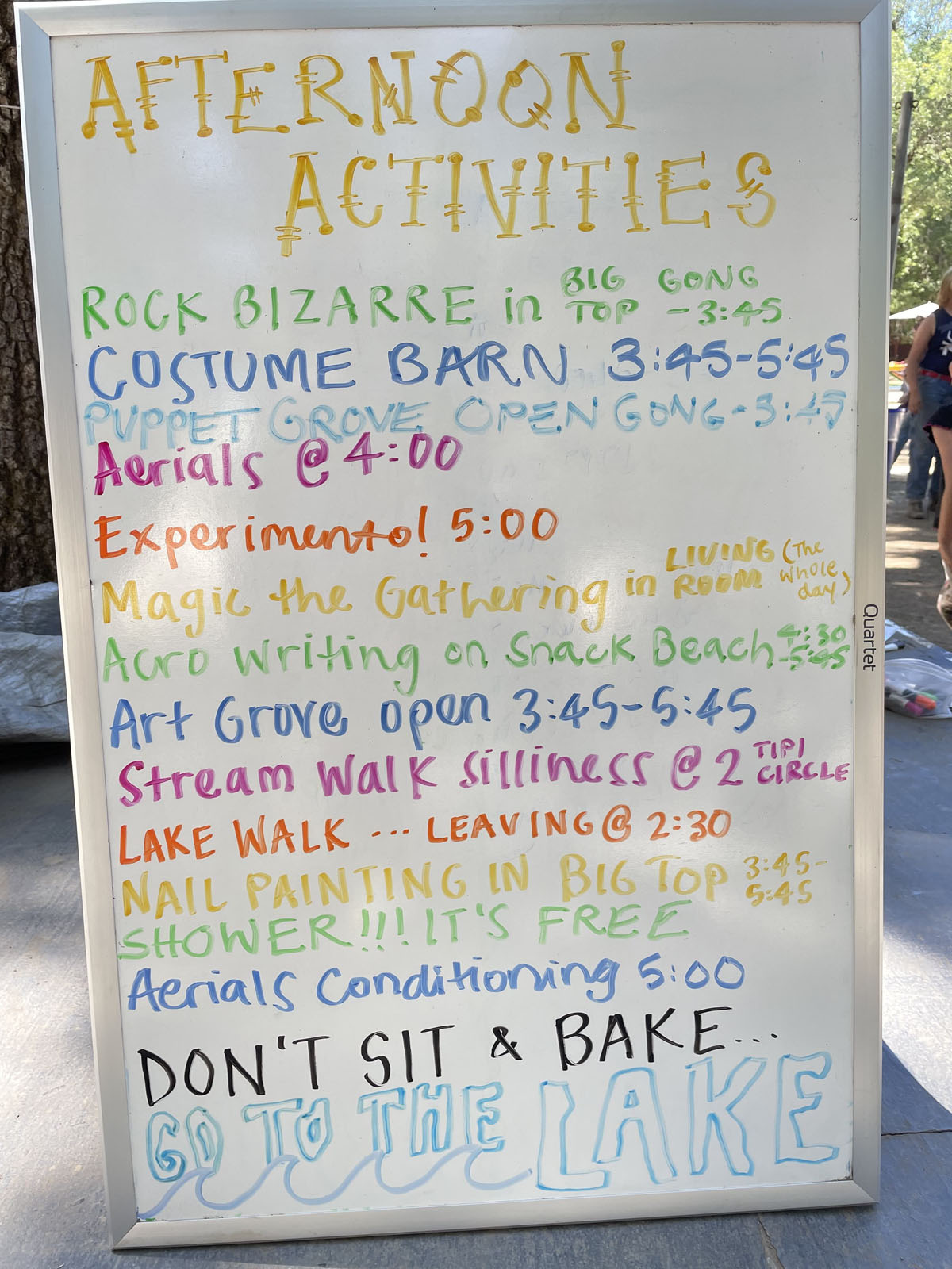 A white board listing afternoon activities that the campers can choose from, such as art, aerials, puppets, nature activities and more